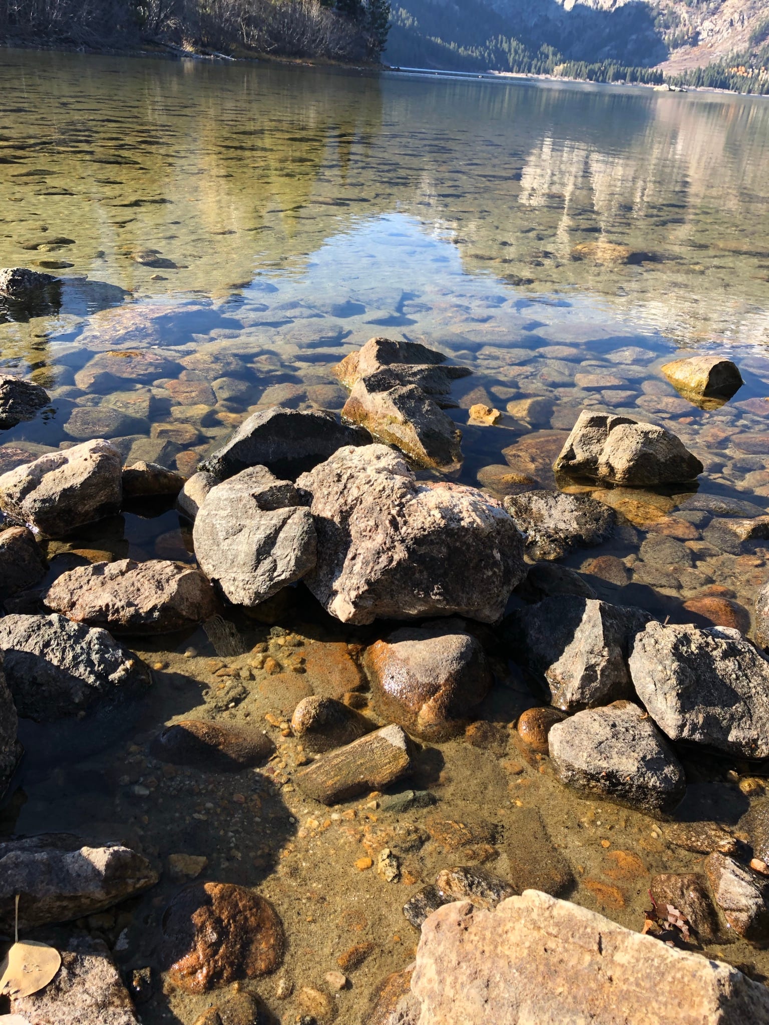 Clear lake water over river rocks — giving with intention and clarity